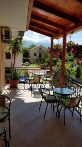 a patio with tables and chairs on a balcony at Sobe Nedović in Budva