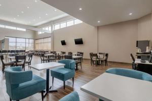un comedor con mesas, sillas y ventanas en MainStay Suites Bricktown - near Medical Center, en Oklahoma City