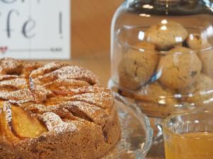 a glass plate with a cake and a glass jar of cookies at Virasol in Dronero