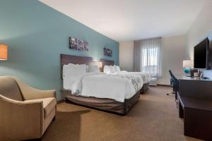 a hotel room with a large bed and a desk at Sleep Inn & Suites Bricktown - near Medical Center in Oklahoma City