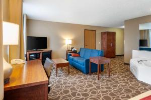 a living room with a blue couch and a television at Comfort Inn Dyersville Near the Field of Dreams in Dyersville