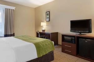a hotel room with a bed and a flat screen tv at Comfort Inn Willow Springs in Willow Springs