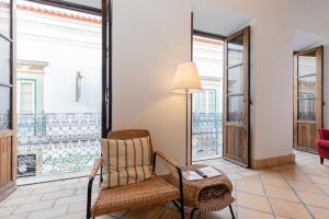 a living room with a chair and a balcony at FARO DOWNTOWN STUDIOS in Faro