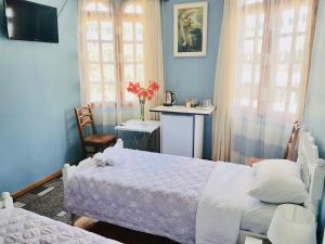 1 Schlafzimmer mit 2 Betten, einem Tisch und Fenstern in der Unterkunft Sweet Home at Ninoshvili 3 in Batumi