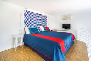 a bedroom with a blue and red bed and a tv at Hotel Torre Barbara in Vico Equense