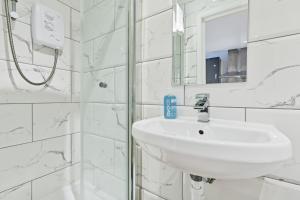 La salle de bains blanche est pourvue d'un lavabo et d'un miroir. dans l'établissement Rainbow Studio - By My Getaways, à Brighton et Hove