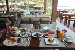 a table topped with plates of food next to a pool at Banana Fan Sea Resort in Chaweng