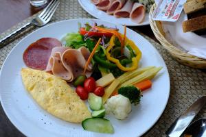 a white plate of food with vegetables and meat at Banana Fan Sea Resort in Chaweng