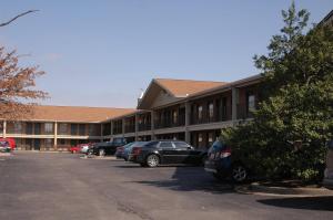 a parking lot in front of a building with cars parked at Bluegrass Extended Stay in Lexington