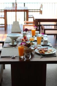 a table with plates of food and glasses of orange juice at Banana Fan Sea Resort in Chaweng