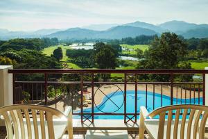 uma varanda com 2 cadeiras e uma piscina em Sir James Resort em Muaklek