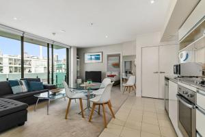 Il comprend une cuisine et un salon avec une table et des chaises. dans l'établissement Two Bedroom Apartment - Pool, Gym & Free Parking!, à Auckland