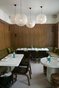 Un comedor con mesas, sillas y luces. en Condesa df, Mexico City, a Member of Design Hotels, en Ciudad de México