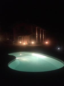 a swimming pool at night with a house in the background at Enoagriturismo L' Acino d'Uva in Cunico