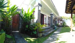 una casa con plantas delante de ella en Guest House Reisya, en Nusa Dua