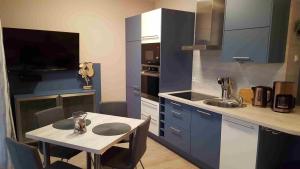 a kitchen with blue cabinets and a table and a sink at Ostsee-Kay in Graal-Müritz