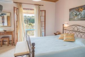 a bedroom with a bed and a desk and a window at Nikos & Vivi Studios in Perivólion