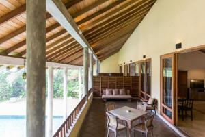 uma grande sala de estar com mesa e cadeiras em Villa Saffron Hikkaduwa em Hikkaduwa