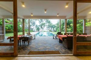 a patio with tables and chairs and a pool at Villa Saffron Hikkaduwa in Hikkaduwa