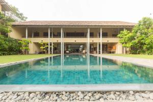 a swimming pool in front of a building at Villa Saffron Hikkaduwa in Hikkaduwa