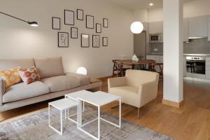 un soggiorno con divano, tavolo e sedie di Eguzki by FeelFree Rentals a San Sebastián