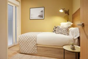 una camera con letto, tavolo e finestra di Eguzki by FeelFree Rentals a San Sebastián
