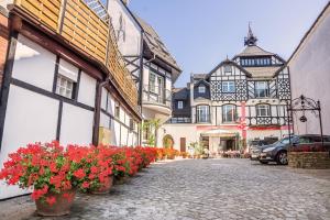 a cobblestone street with flowers in front of buildings at Hotel Rejs in Ustka