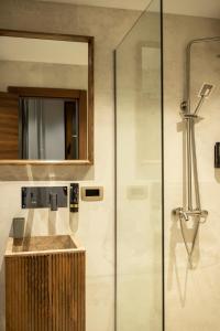 a bathroom with a shower with a sink and a mirror at Boulevard Exclusive in Prishtinë