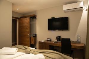a hotel room with a desk and a television on the wall at Boulevard Exclusive in Pristina