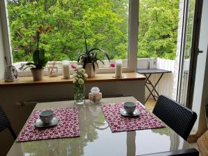 a dining room table with two chairs and a table with two cups at Scandinavian Breeze Apartment in Klaipėda