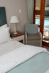 - une chambre avec un lit, une chaise et une fenêtre dans l'établissement Oleander Guest House, à Kimberley