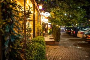 a cobblestone sidewalk with trees and cars parked on a street at Boulevard Exclusive in Prishtinë