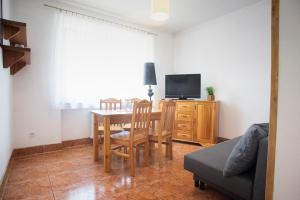 Sala de estar con mesa de comedor y TV en Apartamenty Chata Romana en Szczyrk