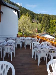 una fila de mesas y sillas blancas en un patio en La Bola, en Roveredo