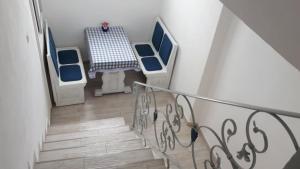 a staircase with blue chairs and a table in a room at KATY&MLADEN in Baška