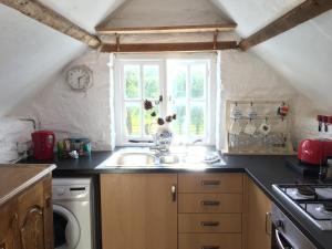 a kitchen with a sink and a window at Little Barn, Greendale Farm in Barnstaple