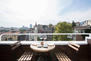 einen Balkon mit Tisch und 2 Weingläsern in der Unterkunft Antique Boutique in Istanbul