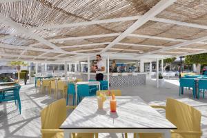 a rendering of a restaurant with tables and chairs at Palmanova Suites by TRH in Magaluf