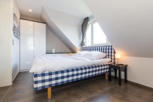 a bedroom with a blue and white bed and a window at Haus Charlotte in Zingst