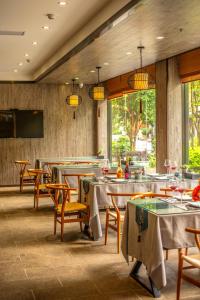 una sala da pranzo con tavoli, sedie e finestre di Peach Blossom Resort Hotel a Guilin Altre 37 foto