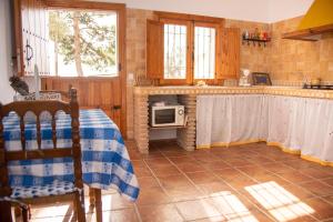 - une cuisine avec une table et un four micro-ondes dans l'établissement Casa Cueva Salamandra, à Pozo Alcón