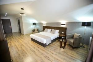 una camera d'albergo con letto e sedia di Crystal Hotel & SPA a Bakuriani Altre 37 foto