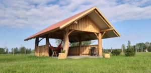 einen Pavillon mit einer Schaukel auf einem Feld in der Unterkunft Zagroda Jakubka in Myszyniec