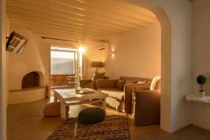 a living room with a couch and a table at Cova Mykonos Suites in Elia Beach