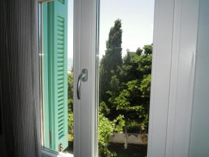 a window with a view of a tree at Blue Dolphin in Batsi