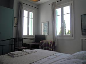 a bedroom with a bed and two windows at Blue Dolphin in Batsi
