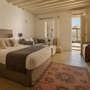 a hotel room with a bed and a dresser at Cova Mykonos Suites in Elia Beach