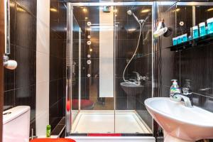 La salle de bains est pourvue d'une douche et d'un lavabo. dans l'établissement Gnn Cosy Apartment, à Tbilissi