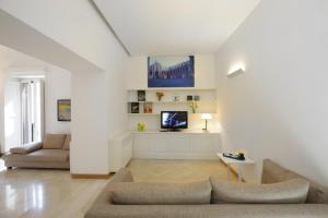 a living room with a couch and a tv at Santacroce Luxury Rooms in Lecce