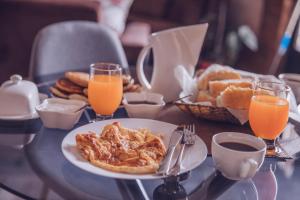 a table with a plate of food and orange juice at Shino in Kazbegi